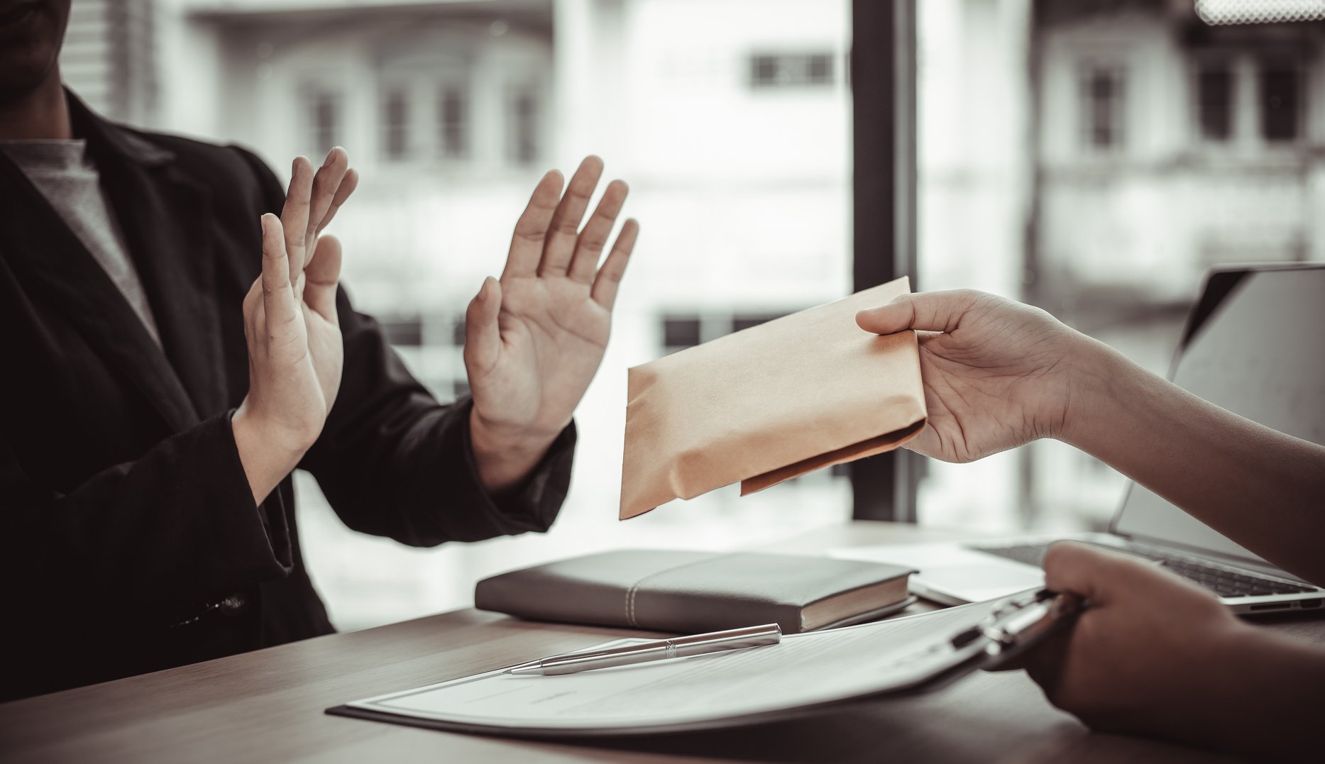 Man Handing Out Envelope With Cash to Bribe Employee